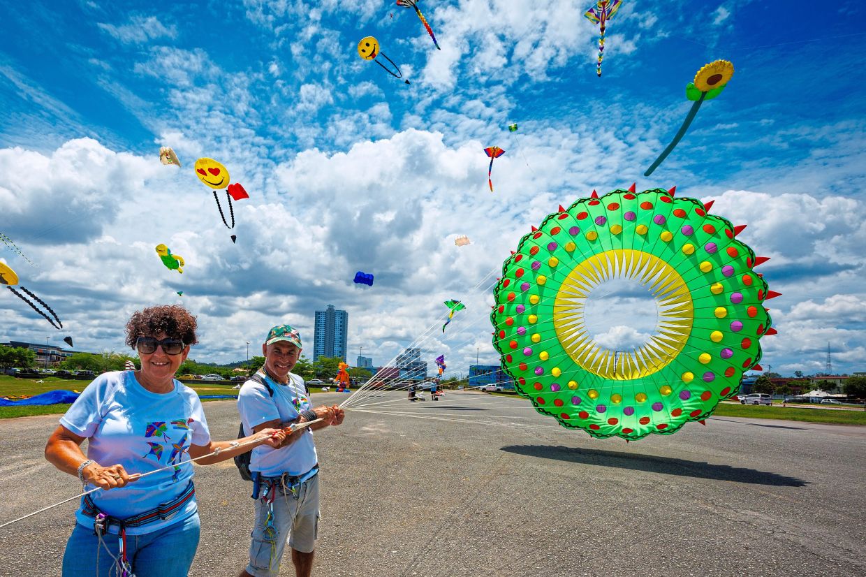 Brazilian participants Gheno Sandra and Guilerme Linates Palau flying a colourful flag at the festival. — Photos by ZULAZHAR SHEBLEE/The Star