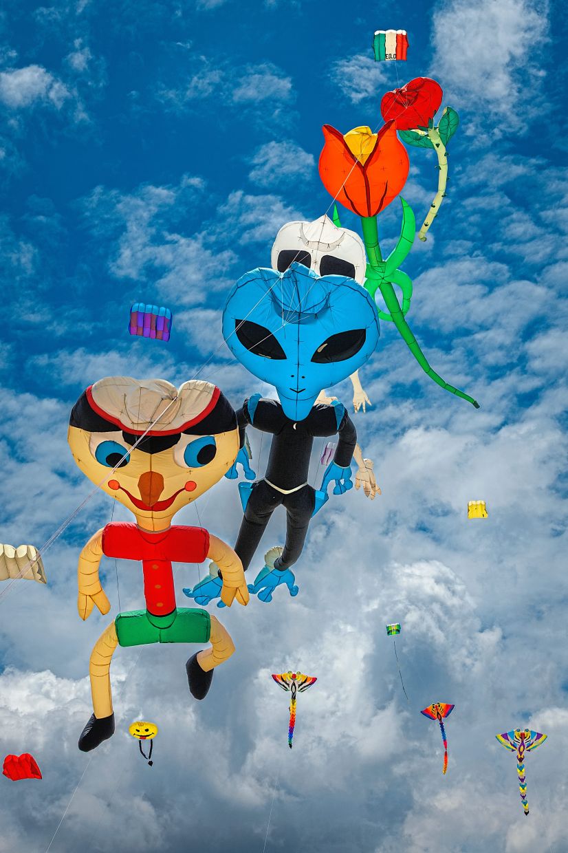 Kites in the shape of toy figures and flowers sharing the sky at the Borneo International Kite Festival.