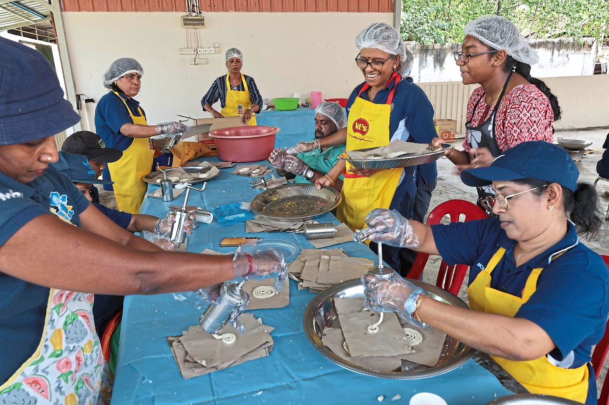 Volunteers making murukku at Sri Maha Mariamman Devasthanam Temple for distribution to prisoners and hospital patients.