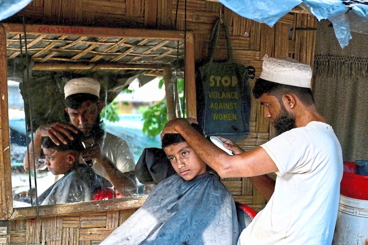 Keeping it neat: A Rohingya refugee getting his hair cut at a barber shop at Balukhali camp in Ukhia. — AFP