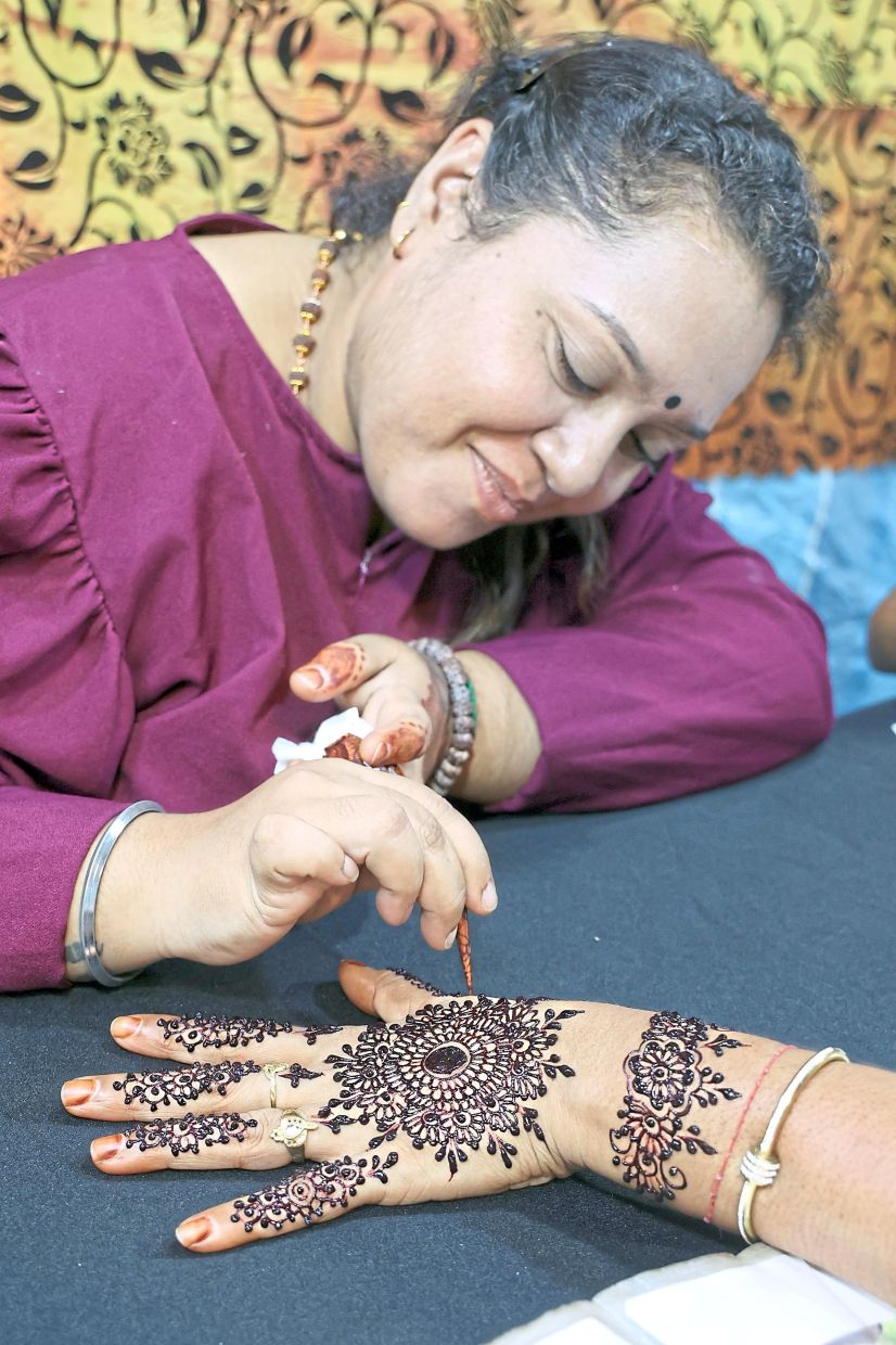 Henna artist Raina is being kept busy at the Deepavali bazaar.
