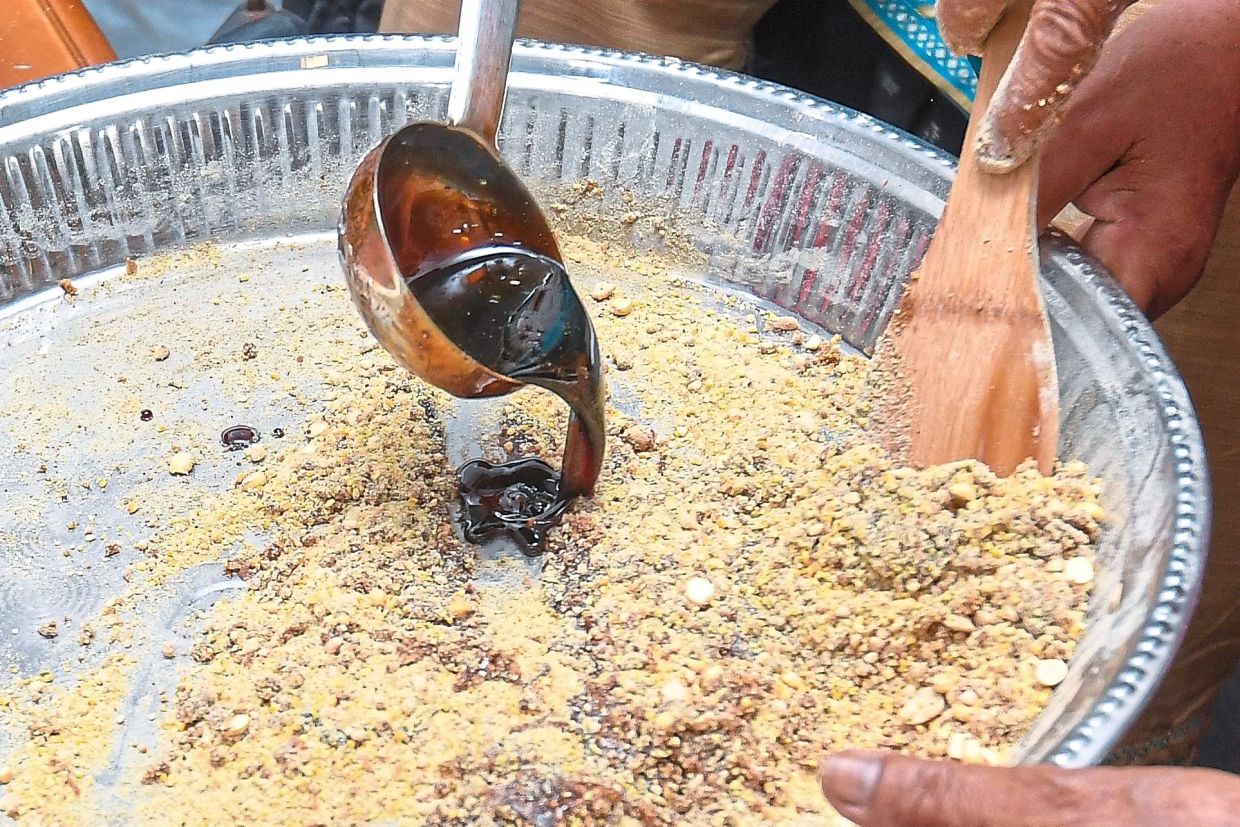 Hot jaggery syrup is poured into the mixture to bind the ingredients together.