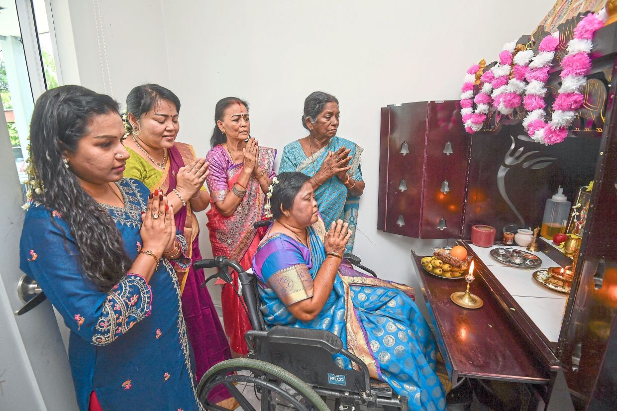 Santhi (in wheelchair) is happy to have her family by her side for Deepavali.