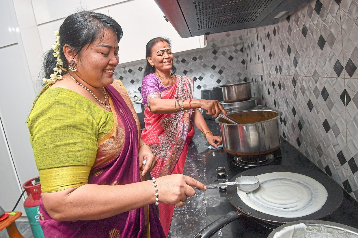 Sisters Kalavani (left) and Eles whip up Deepavali favourites such as thosai and chicken curry.