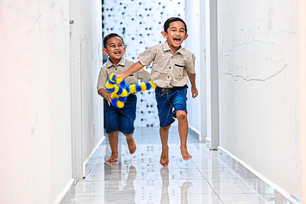 Kids find joy in the little things – even the thoranam – during Deepavali preparations.