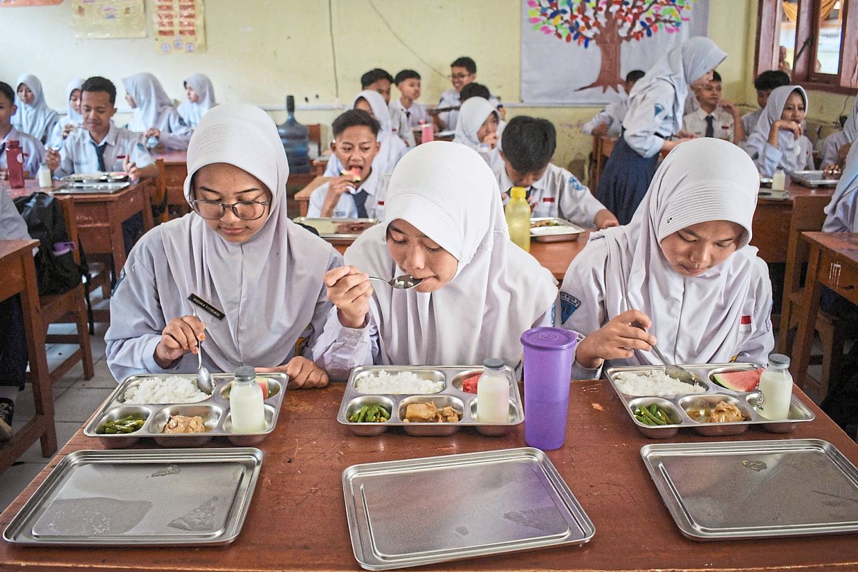 Good intentions: Students eating lunch on the first day of the free-meal programme at a school in Cimahi, West Java, back in January.