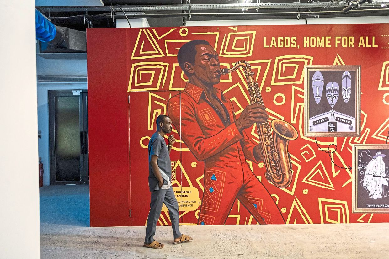 A visitor walks past a mural depicting Fela Kuti at the exhibition in Lagos, Nigeria. Photo: AFP