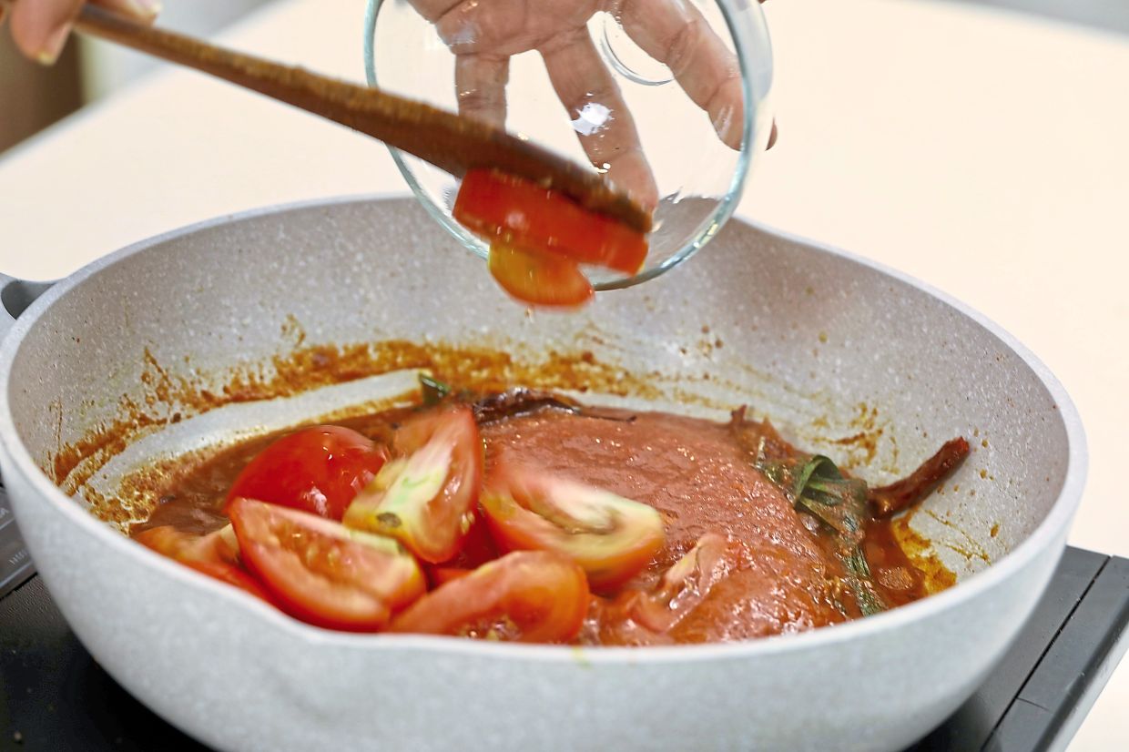 Fresh tomato wedges are added to the sambal.