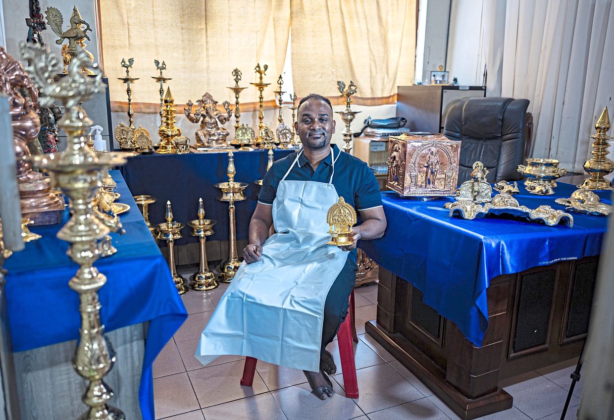 Kanishen showing a variety of oil lamps in his shop that he is polishing for customers.