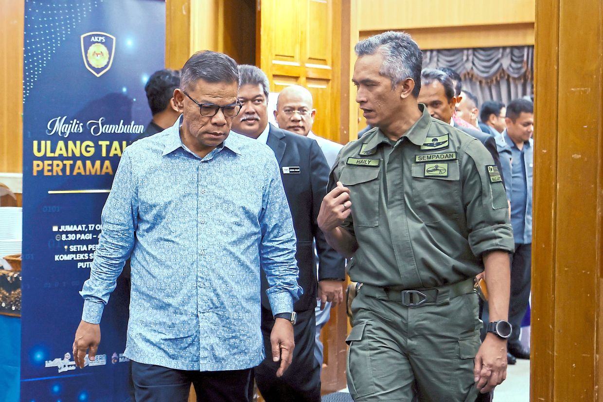 Year of progress: Home Minister Datuk Seri Saifuddin Nasution Ismail (left) speaking with Comm Mohd Shuhaily at AKPS’ first anniversary celebration in Putrajaya. — Bernama