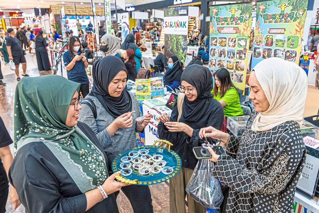 Delicious: Afifah (left) delights visitors with samples of her homemade traditional cakes.