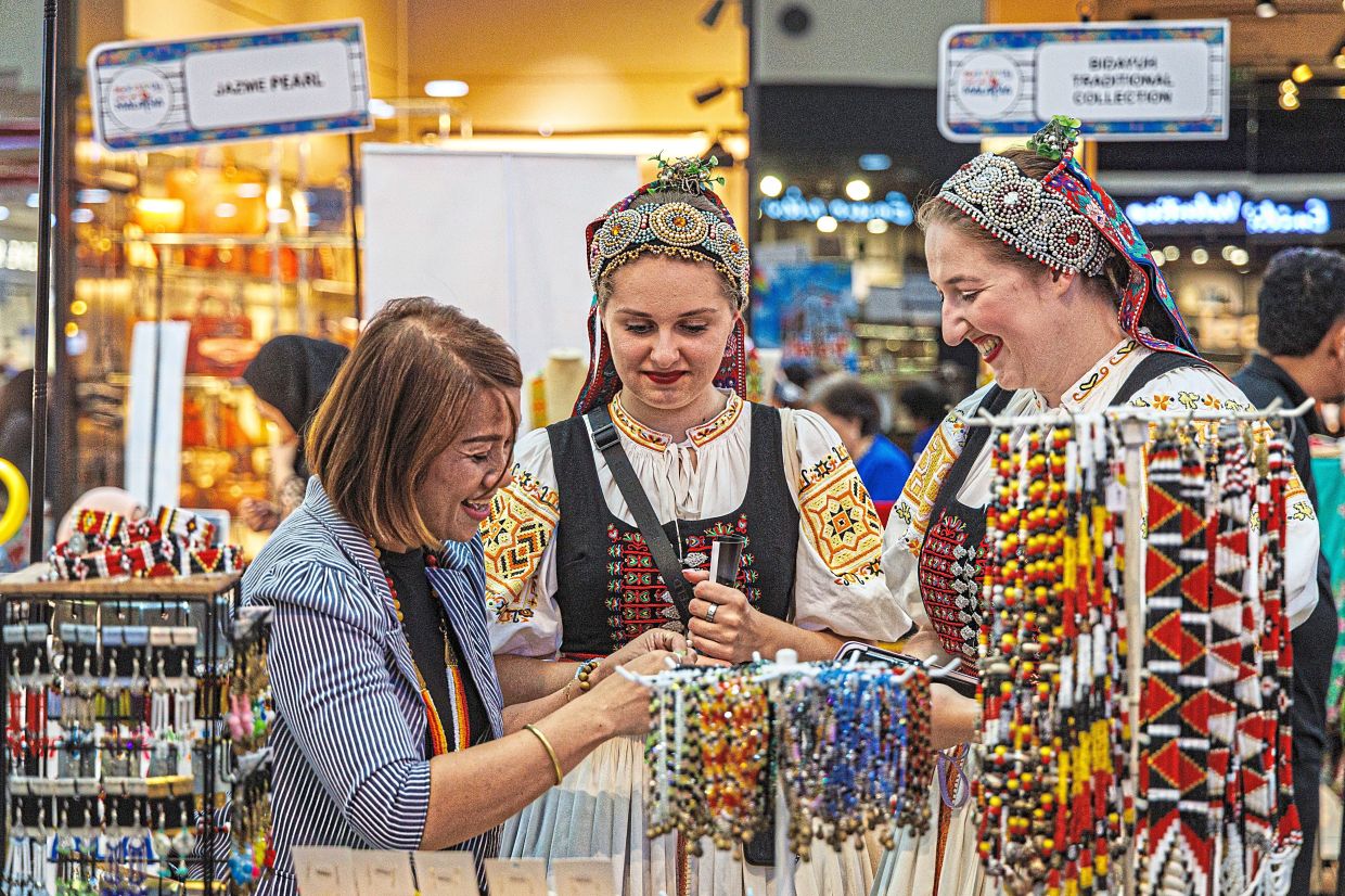 Intricate: Tourists from Russia having a look at the vibrant display of beadwork at the carnival.