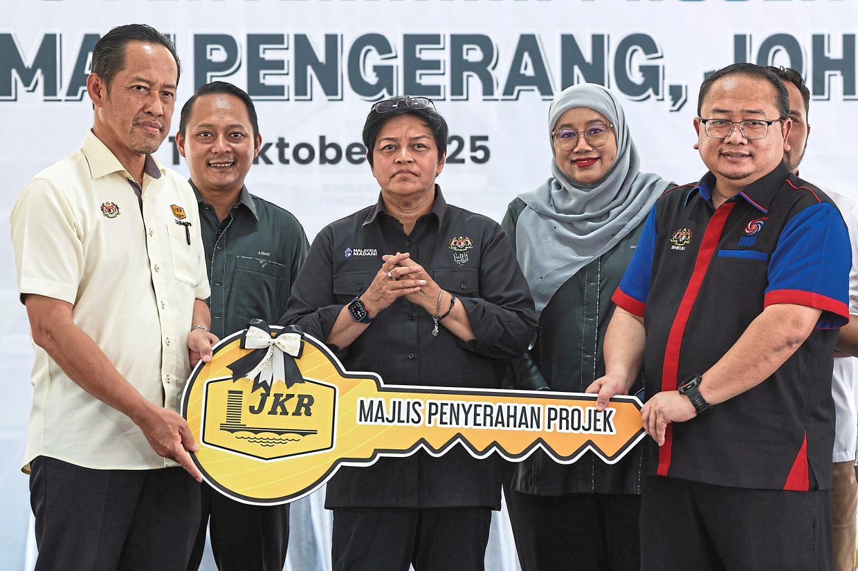 Legal infrastructure: Azalina (centre) witnessing the handover of a replica key for the Johor Pengerang court building between the Johor Public Works Department and Legal Affairs Department. — Bernama