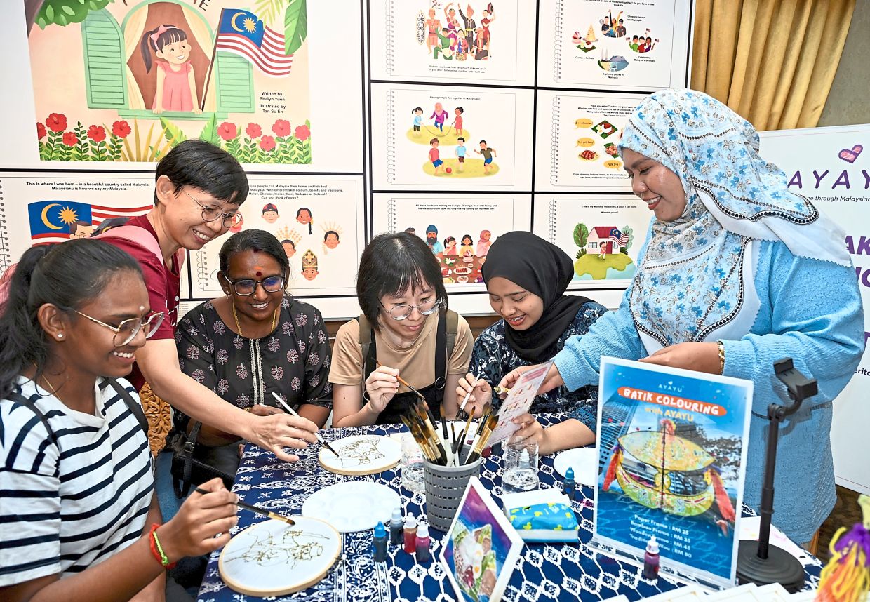 Strokes of harmony: (From left) Danusharadas Nelson Dass, MC Lee, Saraswathy Shanmugam, CW Siew, Najiha Zamani and Anis Zam Zam at a batik drawing booth during the Festival Kartun Perpaduan at the National Museum. — RAJA FAISAL HISHAN/The Star
