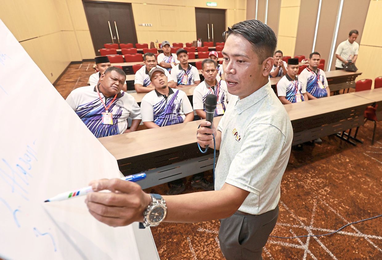 Mohd Syafiq (standing), a former beneficiary of Team Programme, is giving back by working as a facilitator for the same programme.