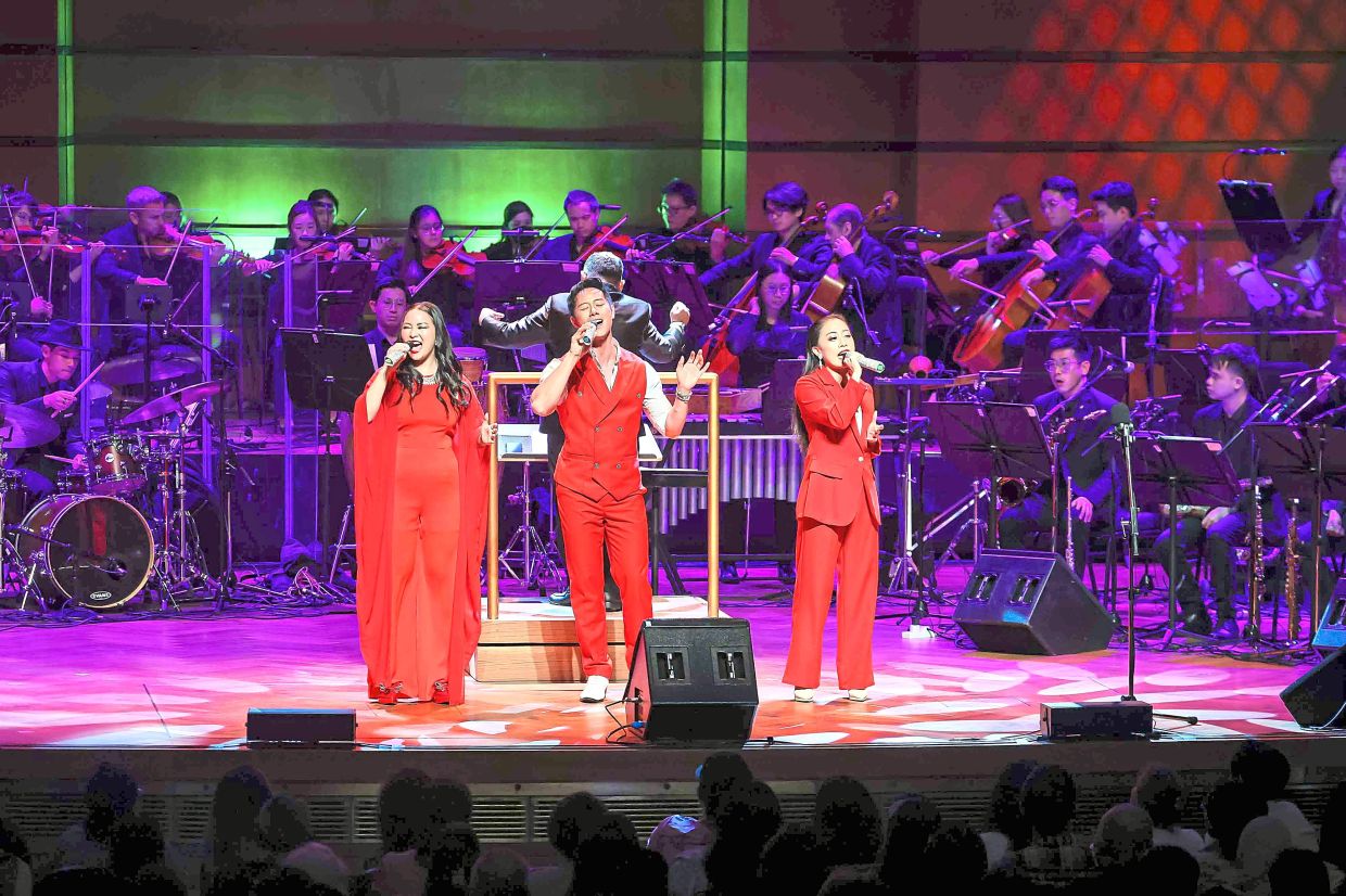 Pop N’ Bop trio taking the stage dressed elegantly in bright red for their performance.
