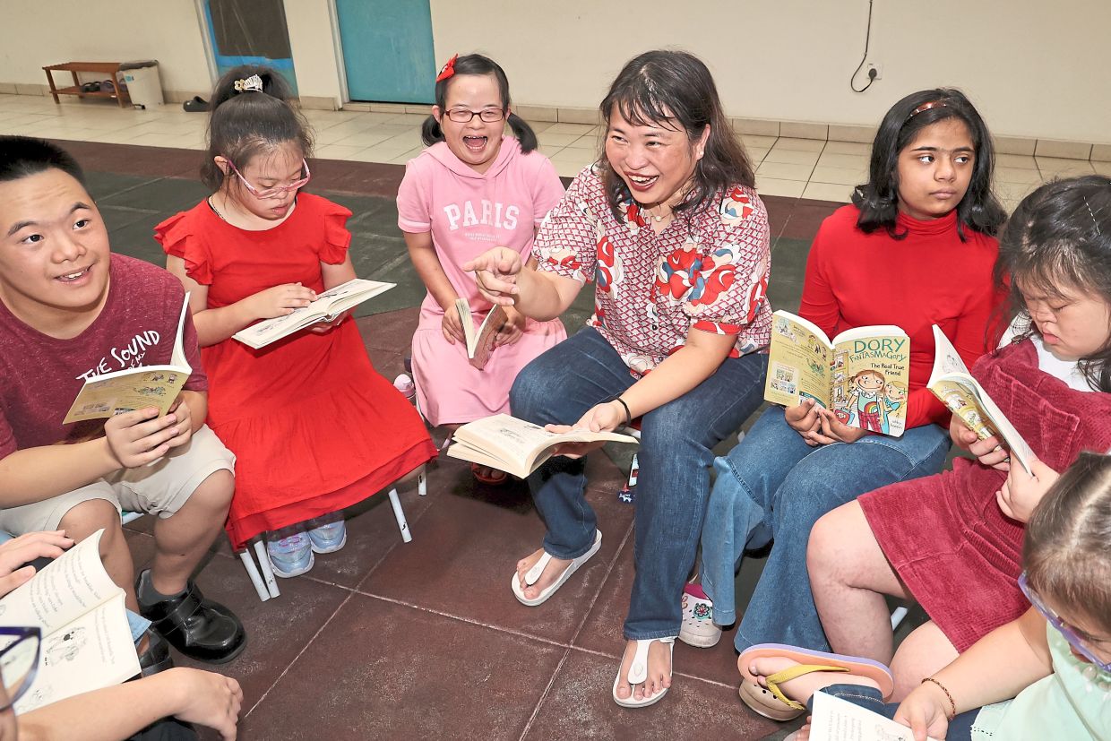 Choo (centre) started the book club to help children with Down syndrome gain confidence and improve their reading skills. Photos: The Star/Art Chen