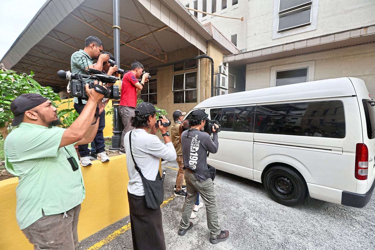 Facing the law: Media personnel approaching the van carrying the 14-year-old accused as it arrives at the Petaling Jaya Court Complex. — LOW BOON TAT/The Star
