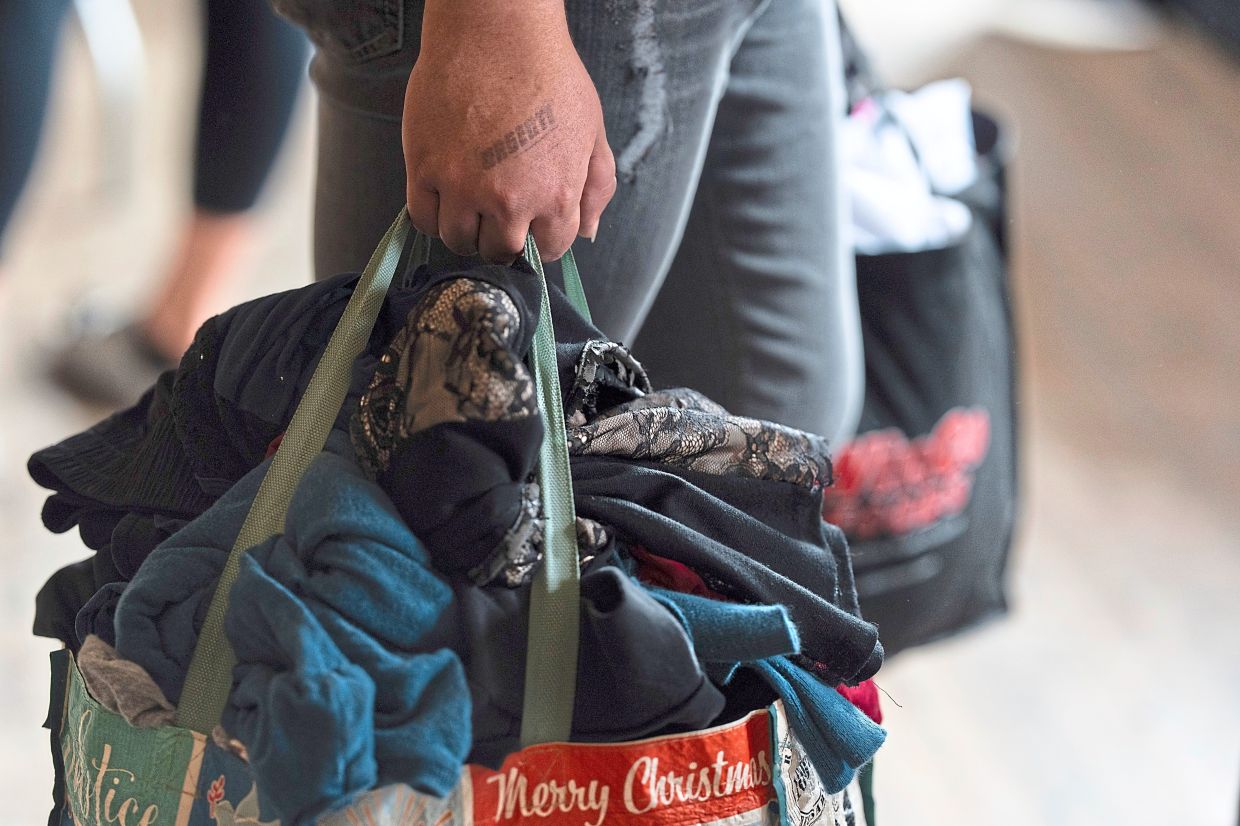 Micailyn Williams holds bags filled with clothing she selected during a clothing swap.