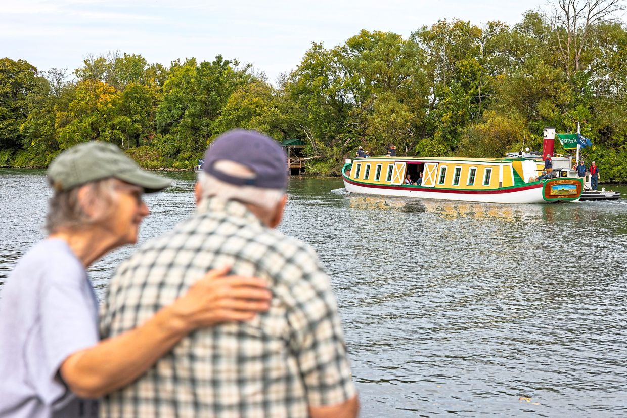 People watching a replica of the ‘Seneca Chief’. — Lauren Petracca/The New York Times