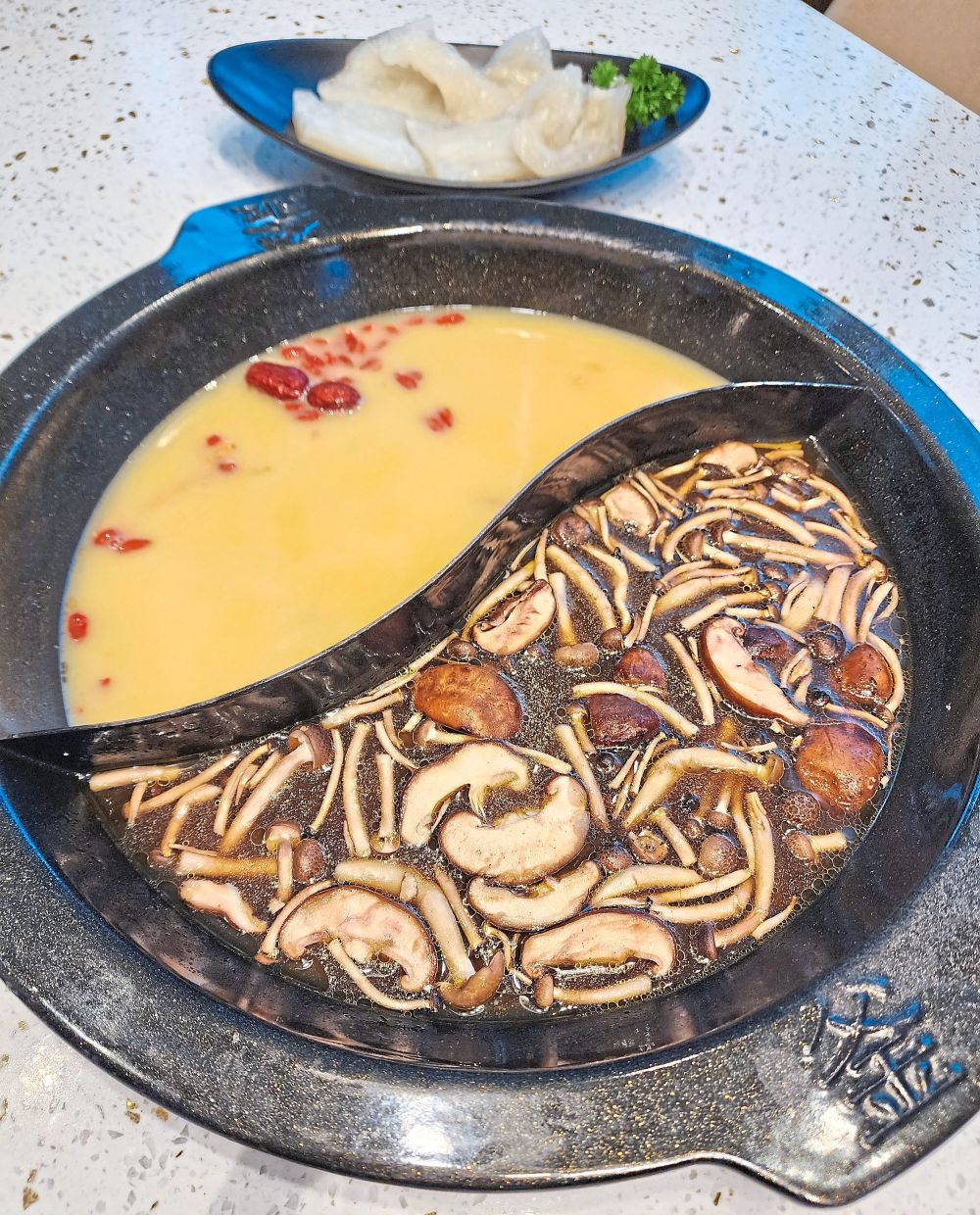 Some of the popular hotpot broth bases include the creamy chicken and fish maw (left) and rustic truffle mushroom. — ABIRAMI DURAI/The Star