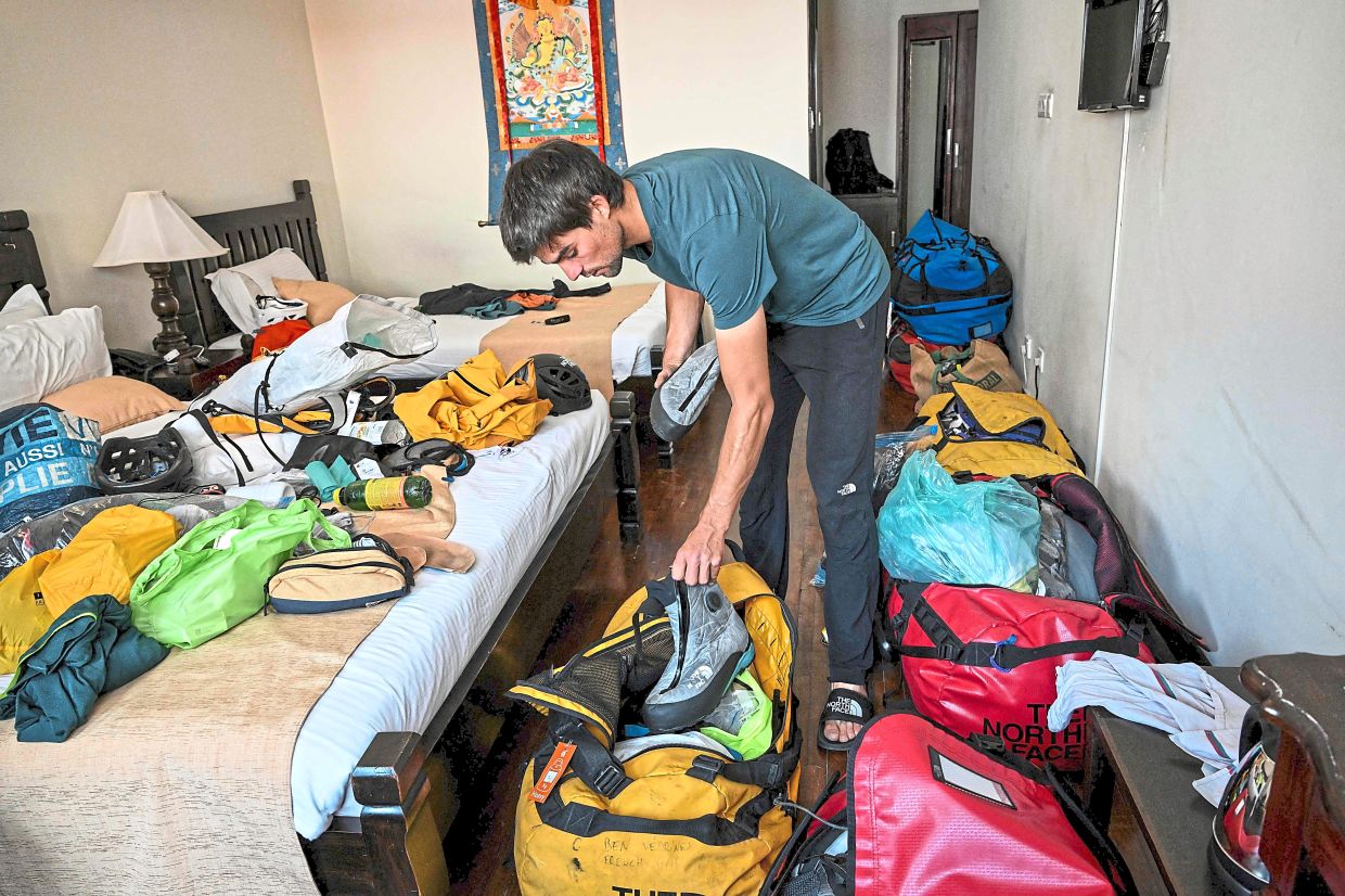 Vedrines sorting his climbing gear on Aug 31 in Kathmandu, before embarking on his climbing expedition. — AFP