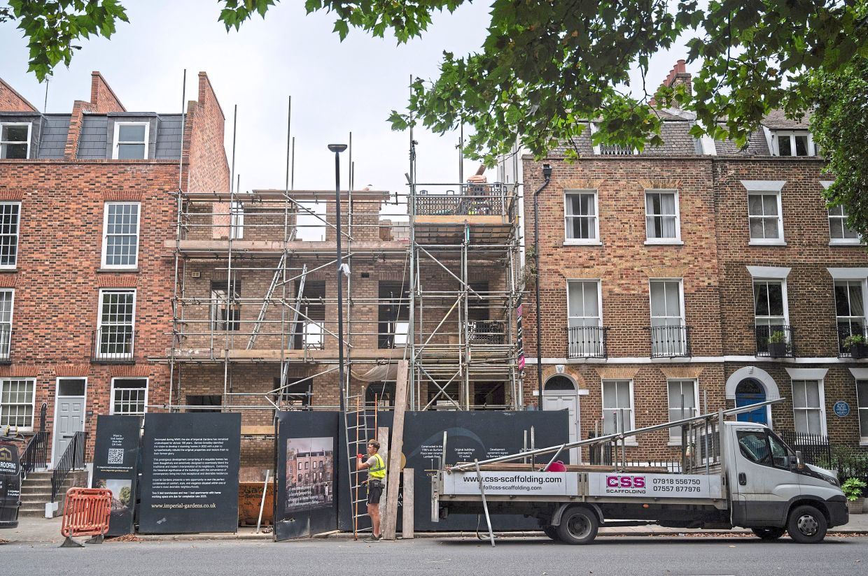 Construction workers work on a row of period homes in Lambeth.