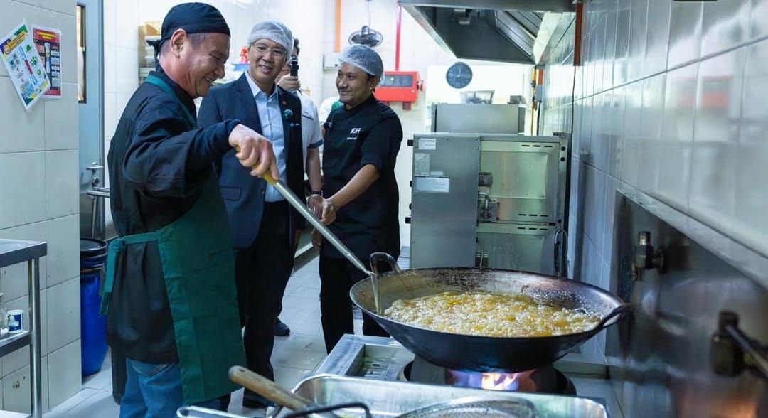 Feeding champions: Badminton Association of Malaysia (BAM) president Tengku Datuk Seri Zafrul Abdul Aziz speaking to the chef at the Academy Badminton Malaysia (ABM) canteen.