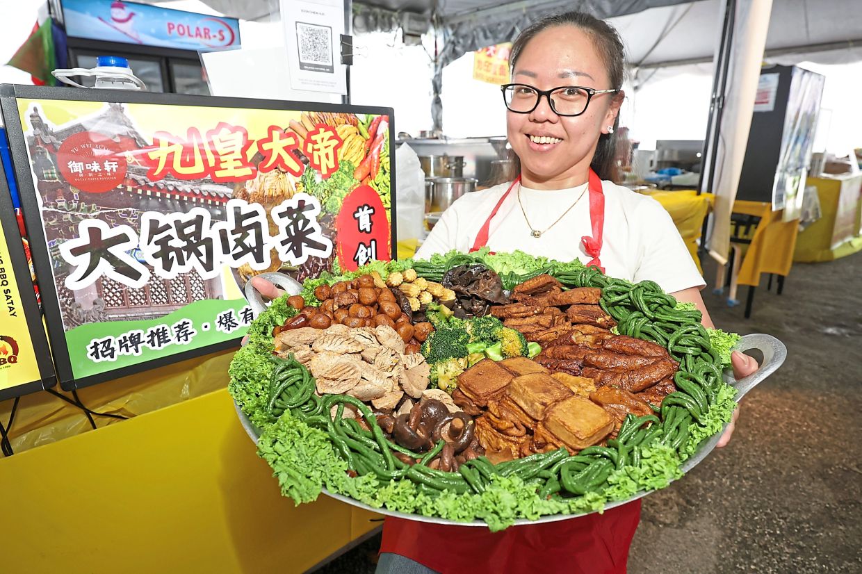 Boon showing a big platter of braised vegetables, a dish that originates from China but has been localised for the Nine Emperor Gods Festival. — CHAN BOON KAI/The Star