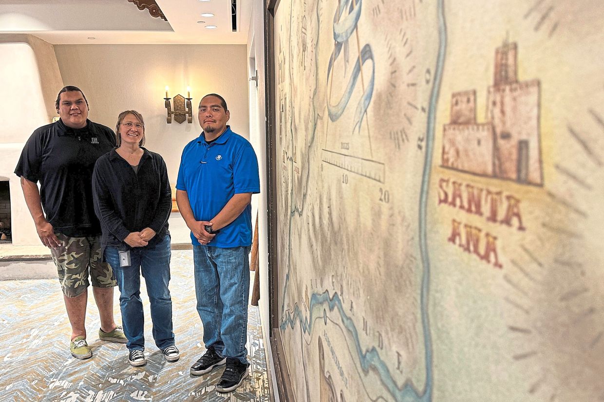 Santa Ana Pueblo Tribal Historic Preservation Department staff members, (from left) technician Thomas Armijo, director Monica Murrell and Lujan pose for a photograph in front a map in Santa Ana Pueblo. — AP