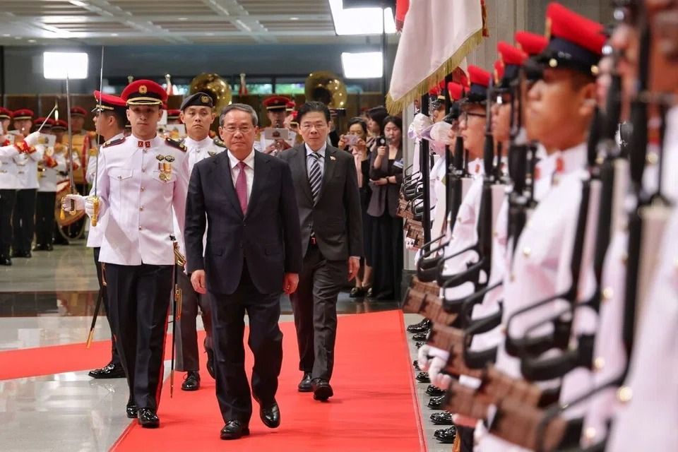 Chinese Premier Li Qiang (front centre), who is visiting Singapore for the first time at the invitation of Prime Minister Lawrence Wong, was welcomed by a guard-of-honour at Parliament House on Oct 25. -- ST PHOTO: KEVIN LIM