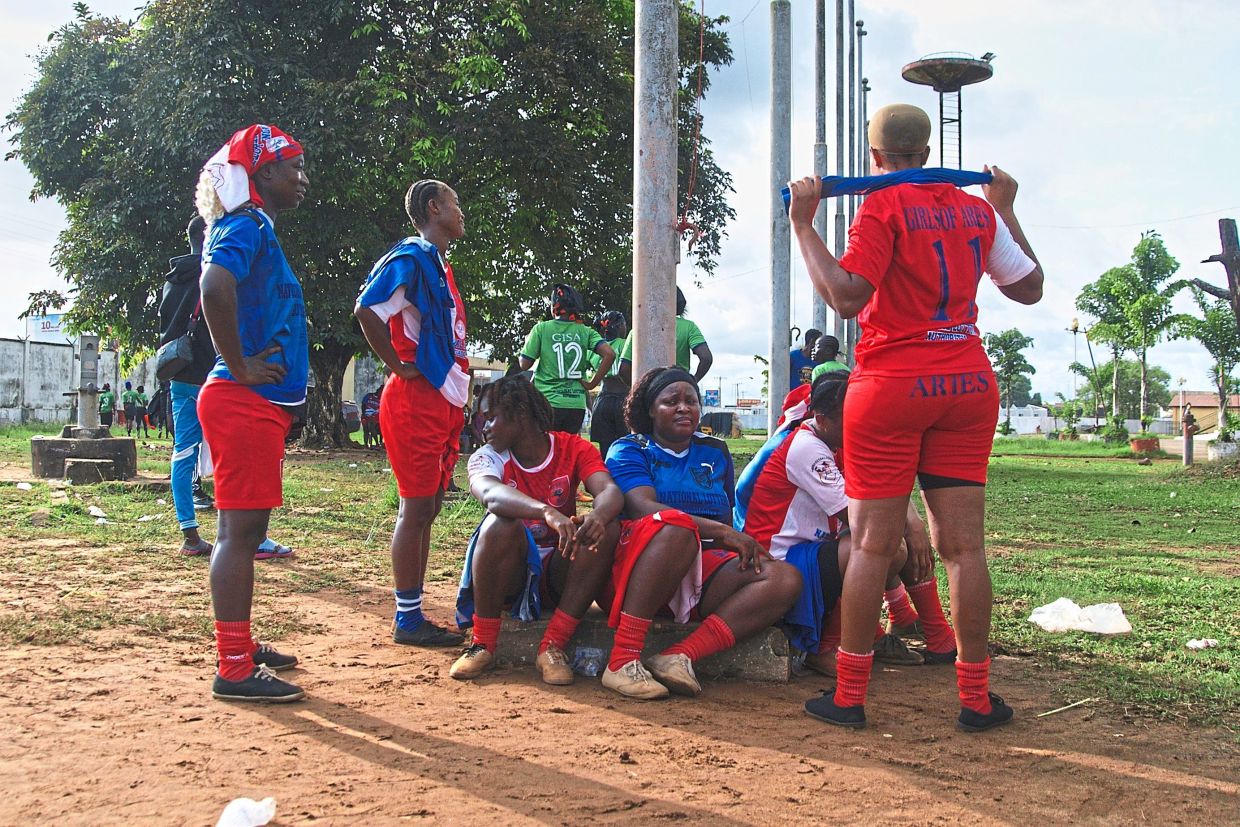 Women on the Girls of Aries kickball team, part of Liberia’s professional kickball league, taking a rest before a match. — AP 