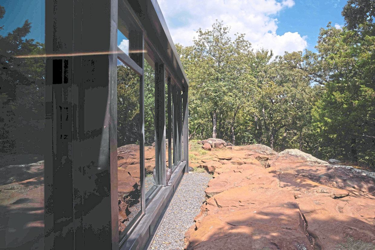 The Recycled Glass House abuts sandstone outcropping. 