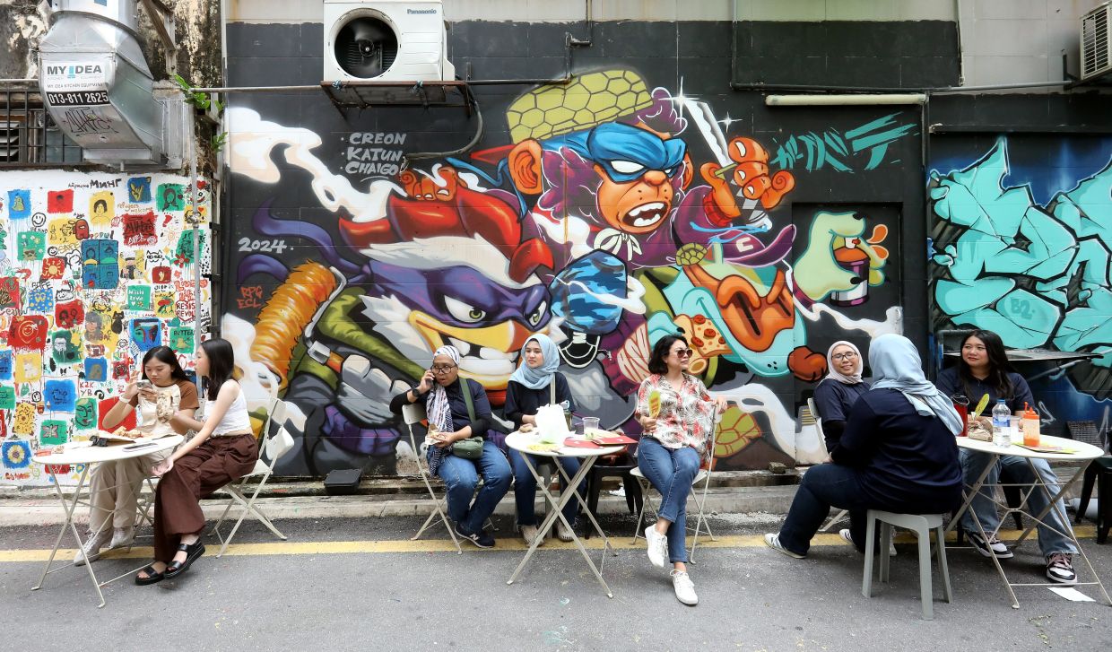 The early hours of the festival are perfect for coffee and a bit of street art gazing around Kampung Attap. Photo: The Star/Azlina Abdullah