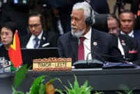 Timor-Leste PM Gusmao hands out sweets to media at Asean Summit
