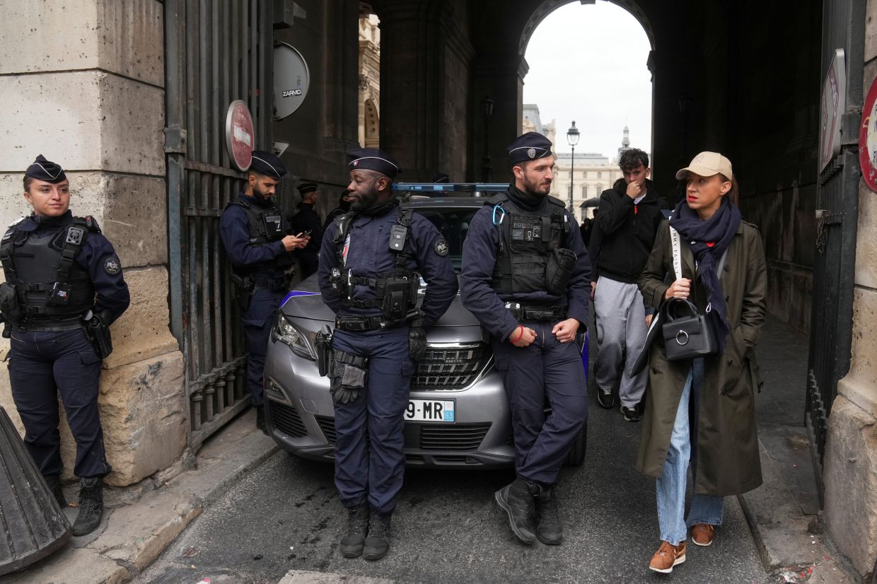 Another image by the same photographer of the same alley and the same police officers, but with a woman in a trench coat and a tan Yankees cap instead of the man, receives much less attention. Photo: AP