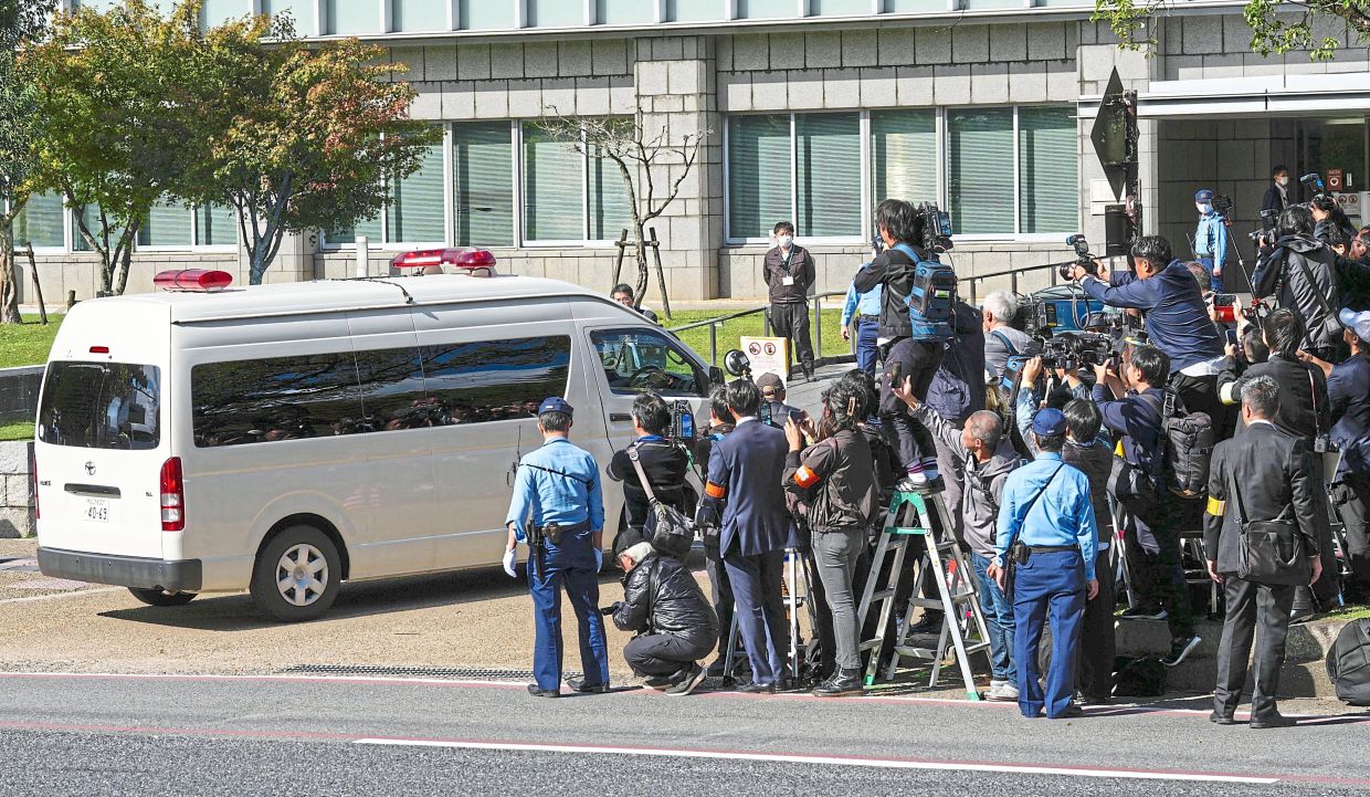 Media gaze: Journalists crowding around as a vehicle believed to be carrying Yamagami (inset) arrives at the Nara District Court. — AP