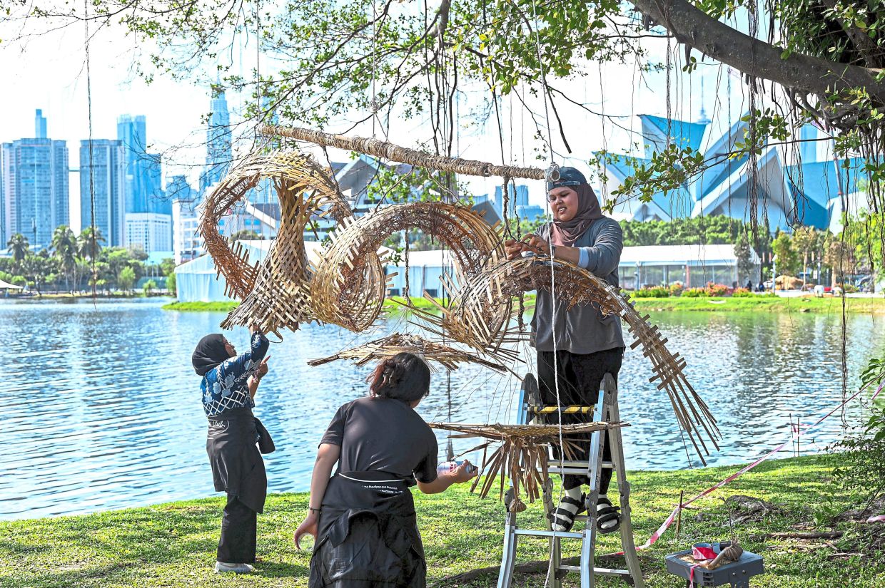 Universiti Teknologi Mara (UiTM) students helping with festival preparations at the launch venue. — Bernama