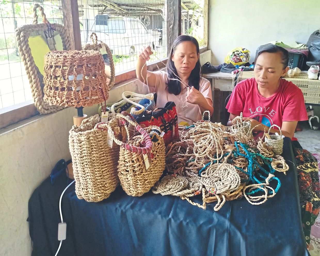 Vida (left) and Siti Amisah Boumin are among the banana trunk crafters who repurpose the waste into daily items.