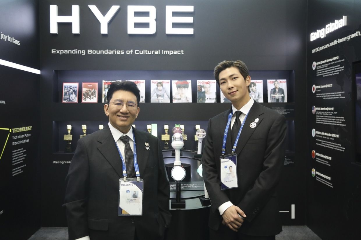 Hybe chairman Bang Si-hyuk and RM pose for a photo while visiting HYBE’s promotional booth during the opening ceremony of the APEC CEO Summit at the Gyeongju Arts Center on Wednesday. - Photo: Yonhap