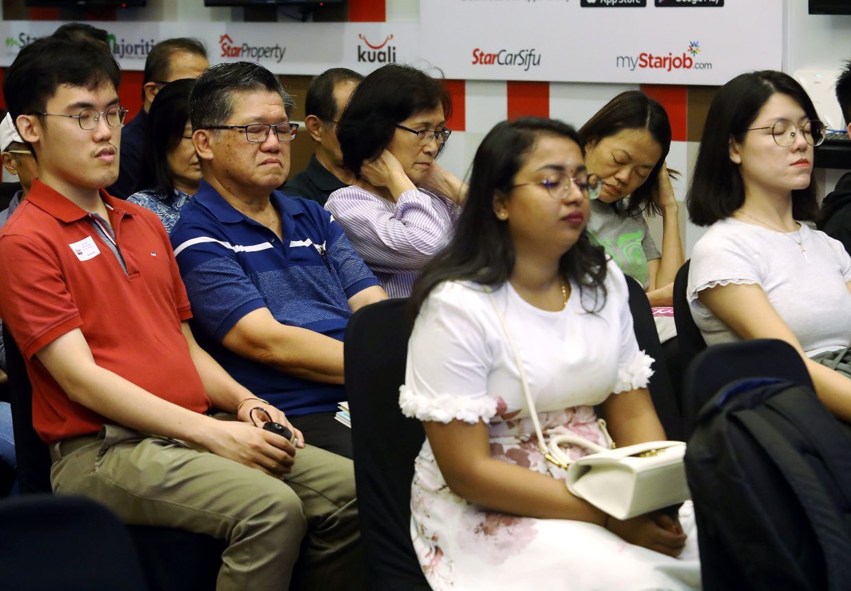 Participants practising mindfulness by closing their eyes and being in the moment.