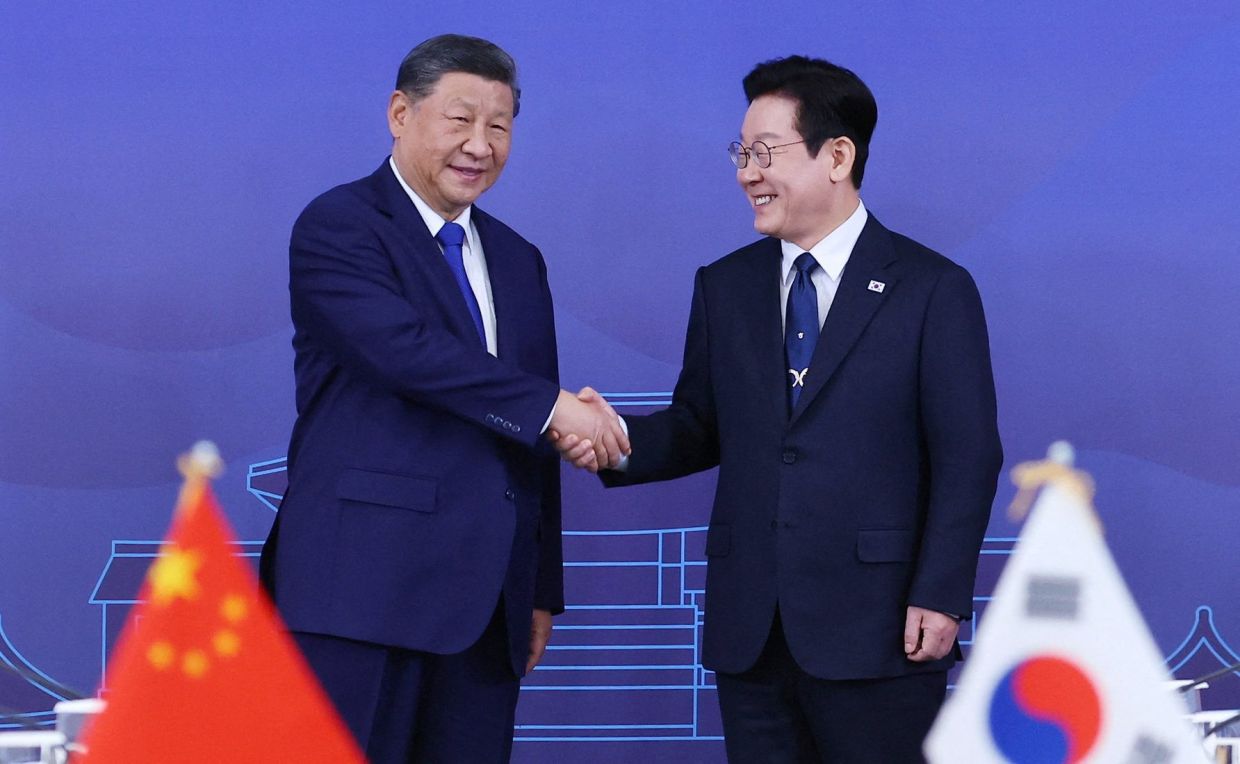 China's President Xi Jinping shakes hands with South Korea's President Lee Jae Myung during their meeting in Gyeongju, South Korea, November 1, 2025. -- Yonhap via REUTERS
