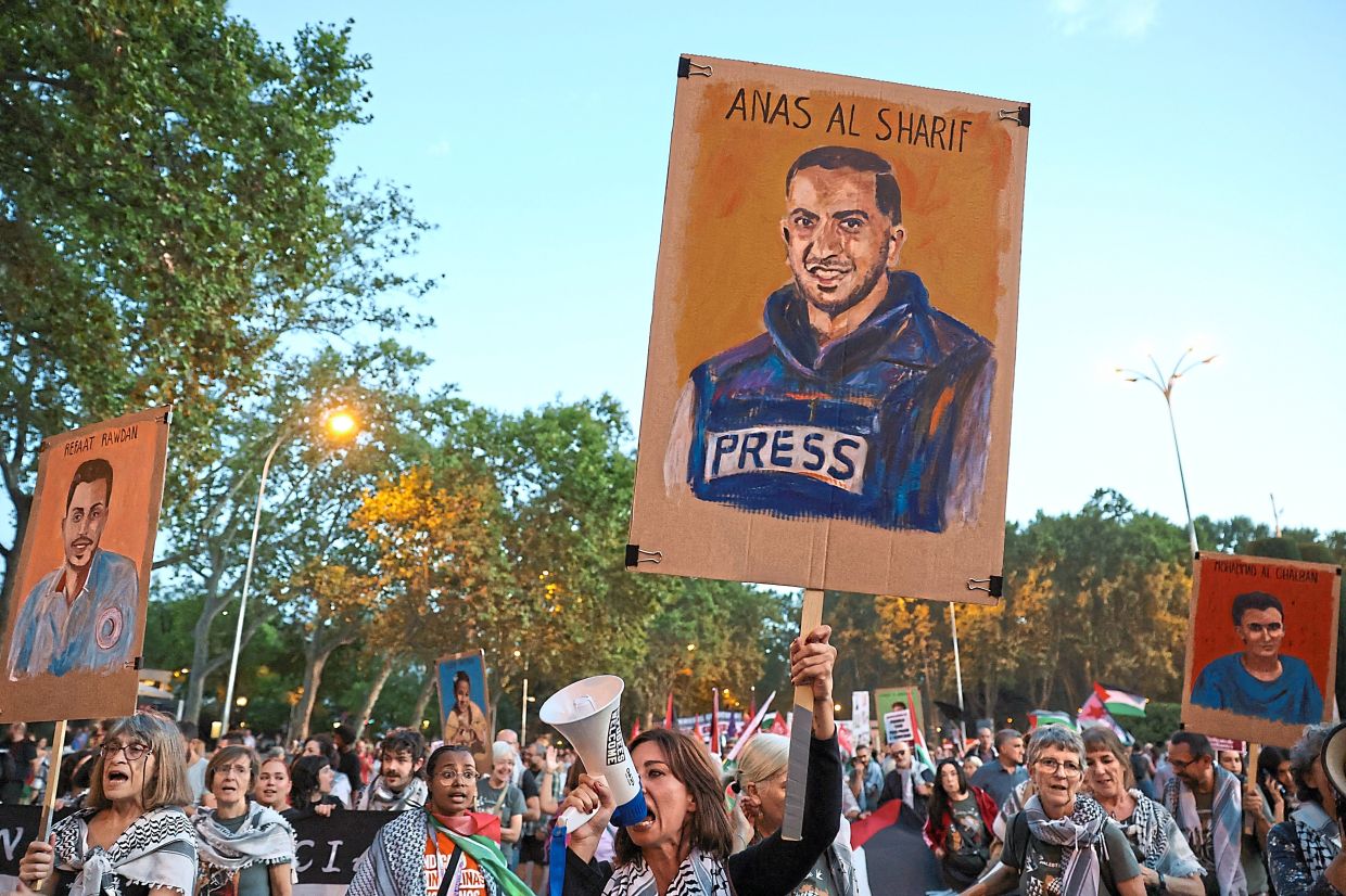 In support: A woman displaying an image of slain Palestinian journalist Anas al-Sharif in a demonstration held in solidarity with Palestinians in Gaza, in Madrid on Oct 15. This past decade has been especially traumatic and deadly for journalists, with 253 killed in Gaza alone. — Reuters