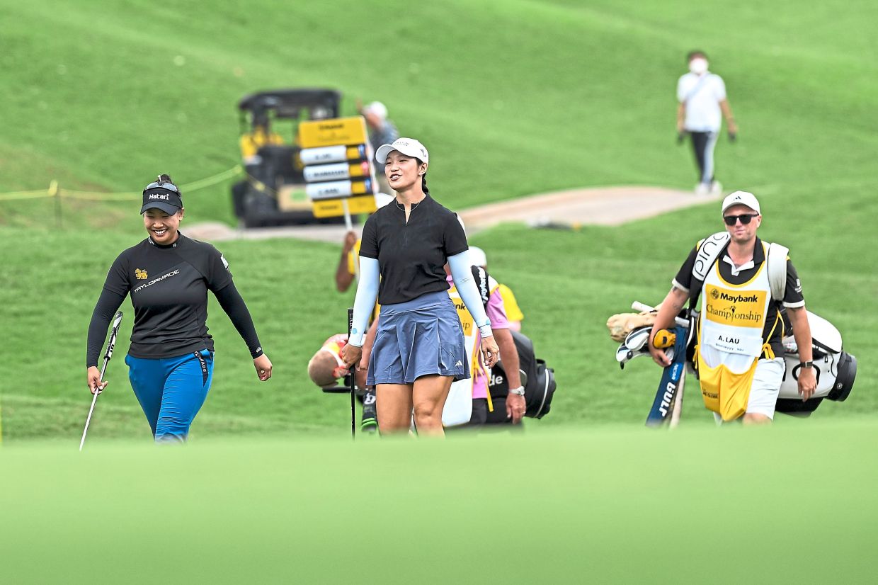 On to the next mission: Ashley Lau (centre) walking along the fairway.