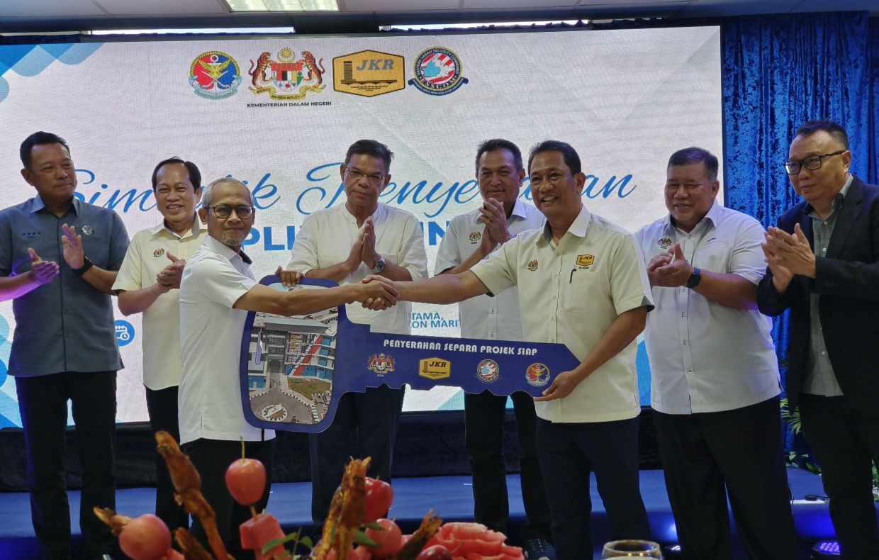 Public Works Department representative Datuk Ir. Jasmi Wahab hands over the symbolic key to Home Ministry Development Division Secretary Ahmad Fuad Apandi, witnessed by Home Minister Datuk Seri Saifuddin Nasution (centre) and Deputy Works Minister Datuk Seri Dr Ahmad Maslan.