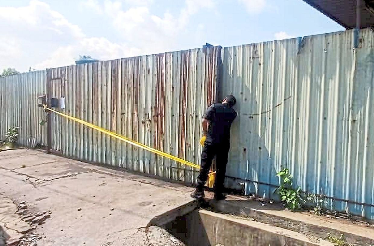 An enforcement staff sealing off the unlicensed makeshift forklift repair workshop in Pandamaran.