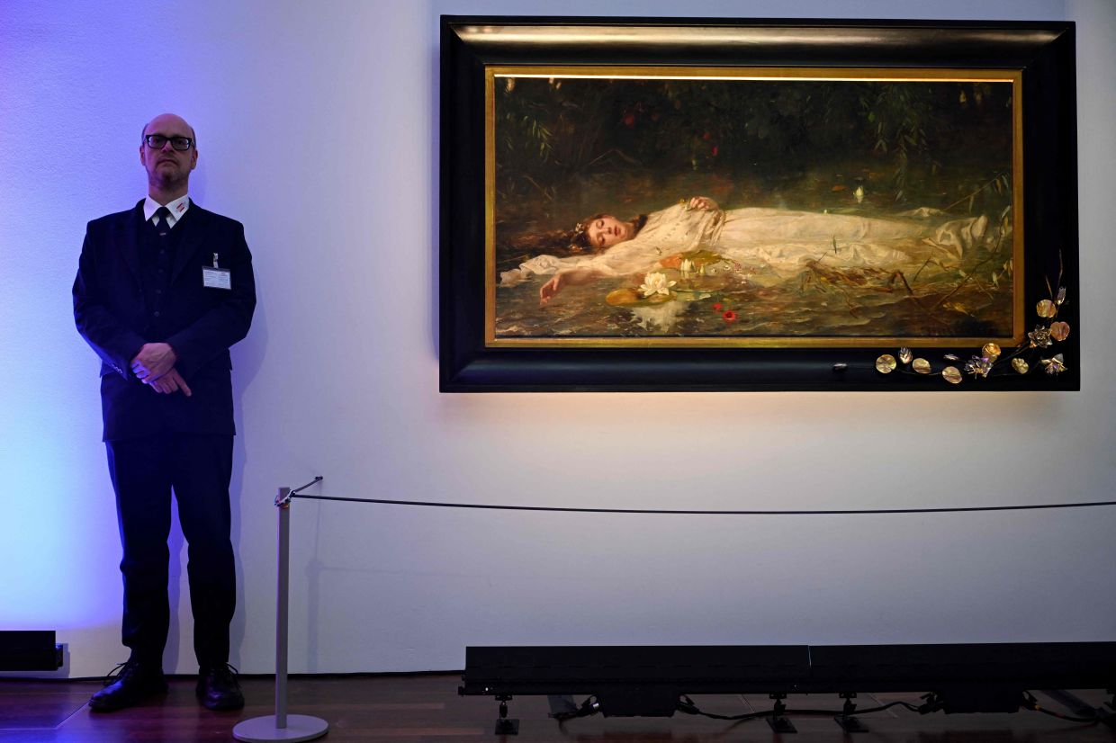 A museum attendant stands beside 'Ophelia' (circa 1900) by German artist Friedrich Heyser. The museum is offering a short guided tour linking Swift’s song to the tragic tale of Ophelia. Photo: AFP