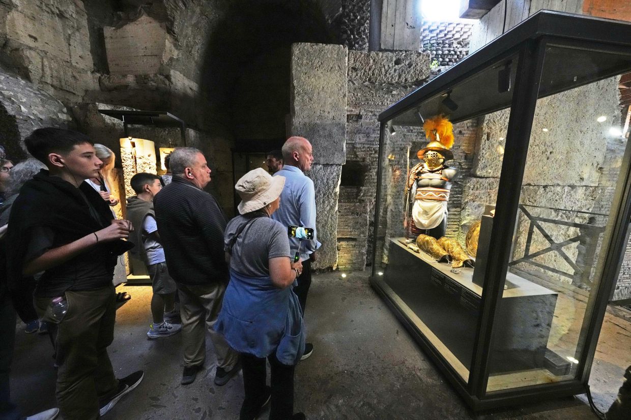 Visitors admiring reconstructions of gladiator’s armours and weapons at the Colosseum.