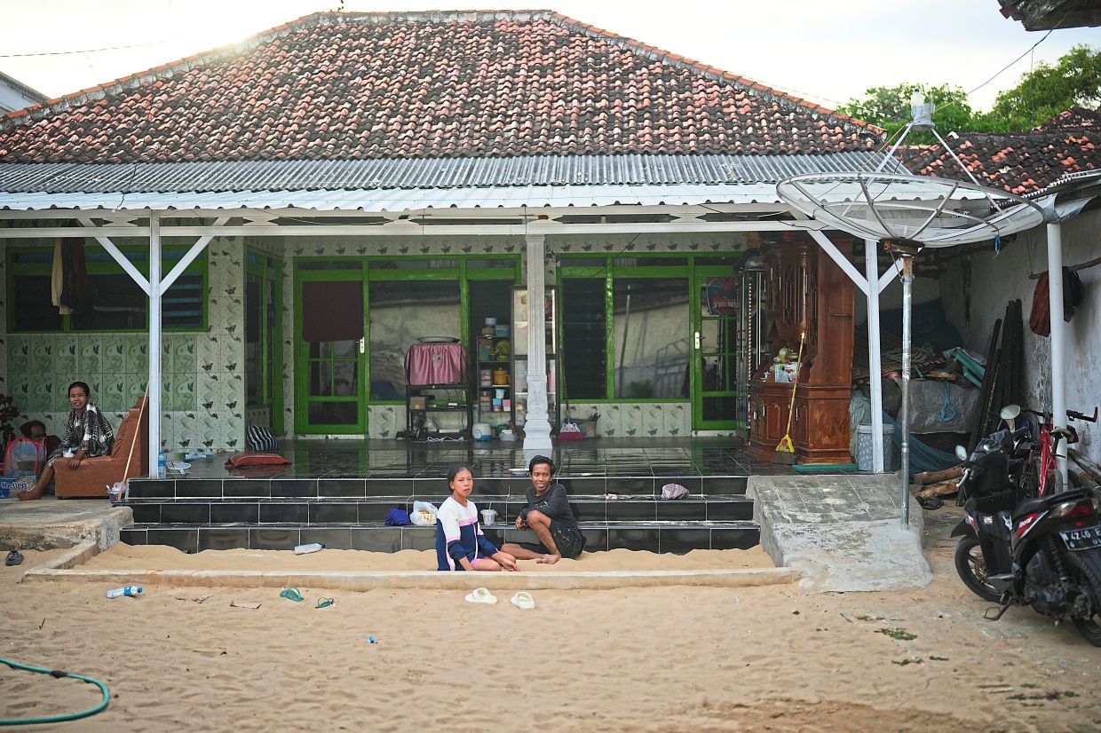 People spend their afternoon in a sandpit which is available in almost every house in Legung Timur village in Sumenep on Madura Island, Indonesia, Tuesday, Sept. 9, 2025. (AP Photo/Dita Alangkara)