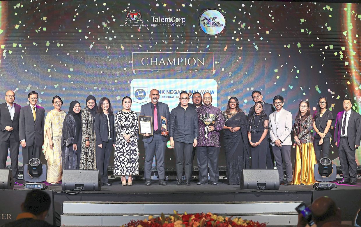 (Sixth from left) Choong and (third from right) Yim with their BNM team celebrating their win with Sim (centre) and Wong (seventh from left). They were honoured for excellence in digital innovation and talent development.